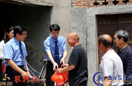 图为检察院领导（左二）与干警走访慰问贫困户。